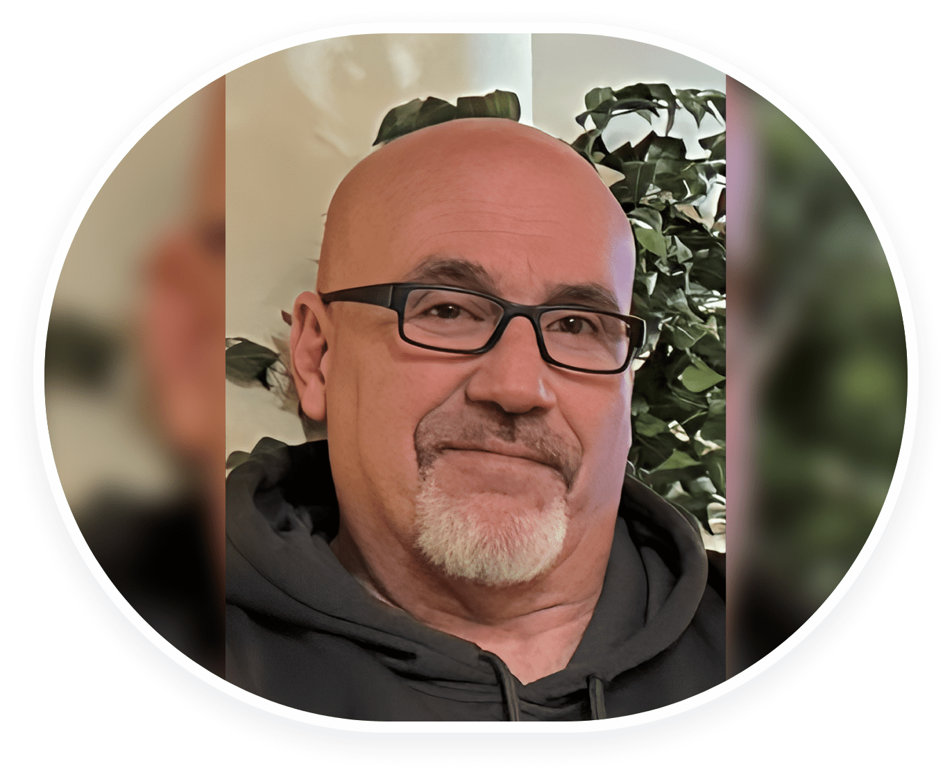 Smiling middle-aged man with glasses in a cozy indoor setting.